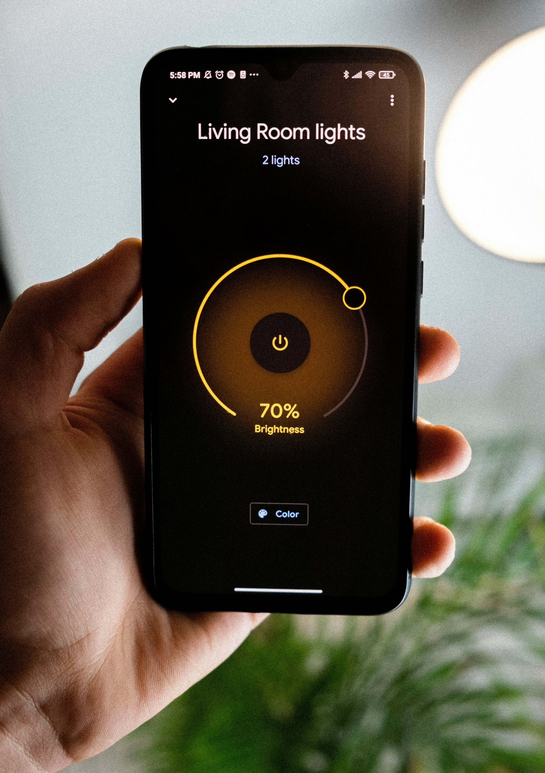 Smartphone screen showing a smart lighting app set to 70% brightness for living room lights.