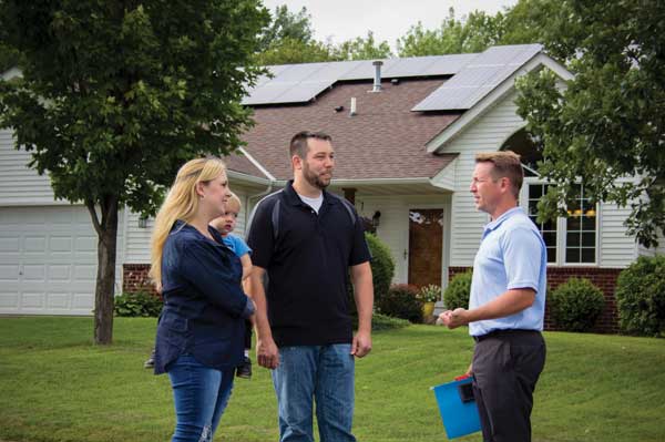 Energy services representative meeting with Dakota Electric members about their solar installation