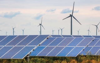 Solar panels and wind turbines in field.