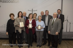 Touchstone energy winners holding their plaques with Dakota Electric board members.