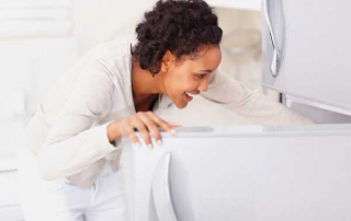 Smiling woman looking in the refrigerator