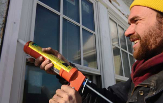man caulking outside window sill