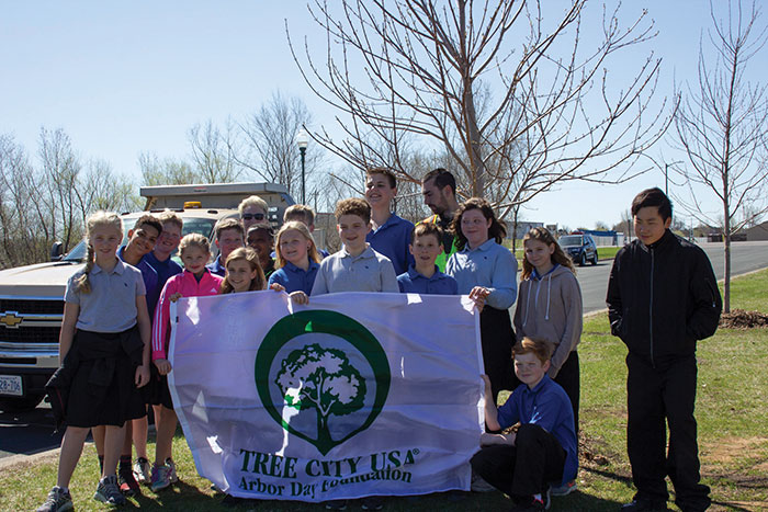 Group of kids holding tree planting banner