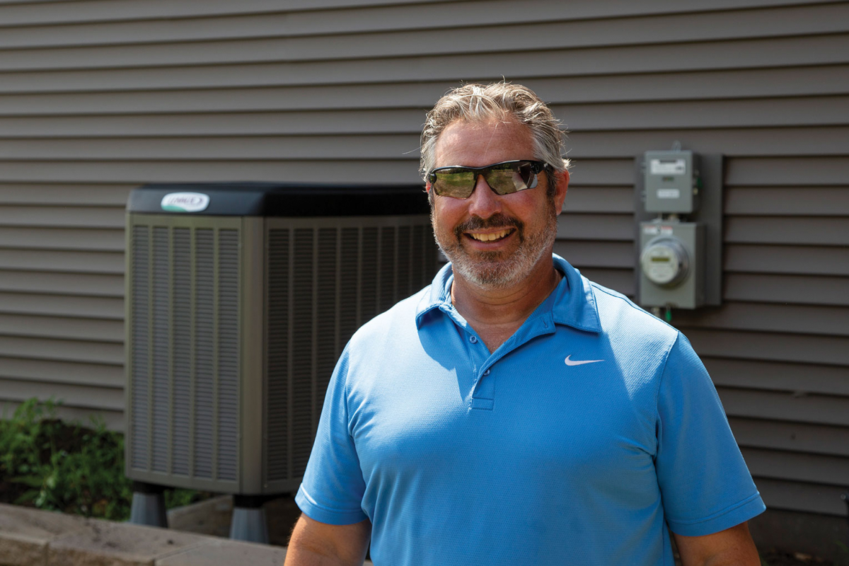 Jeff Neuman displays air source heat pump