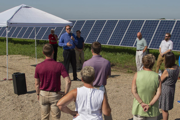 person speaking to crowd at solar panel site