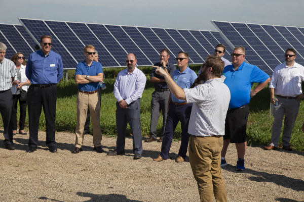 poeple standing by solar panels