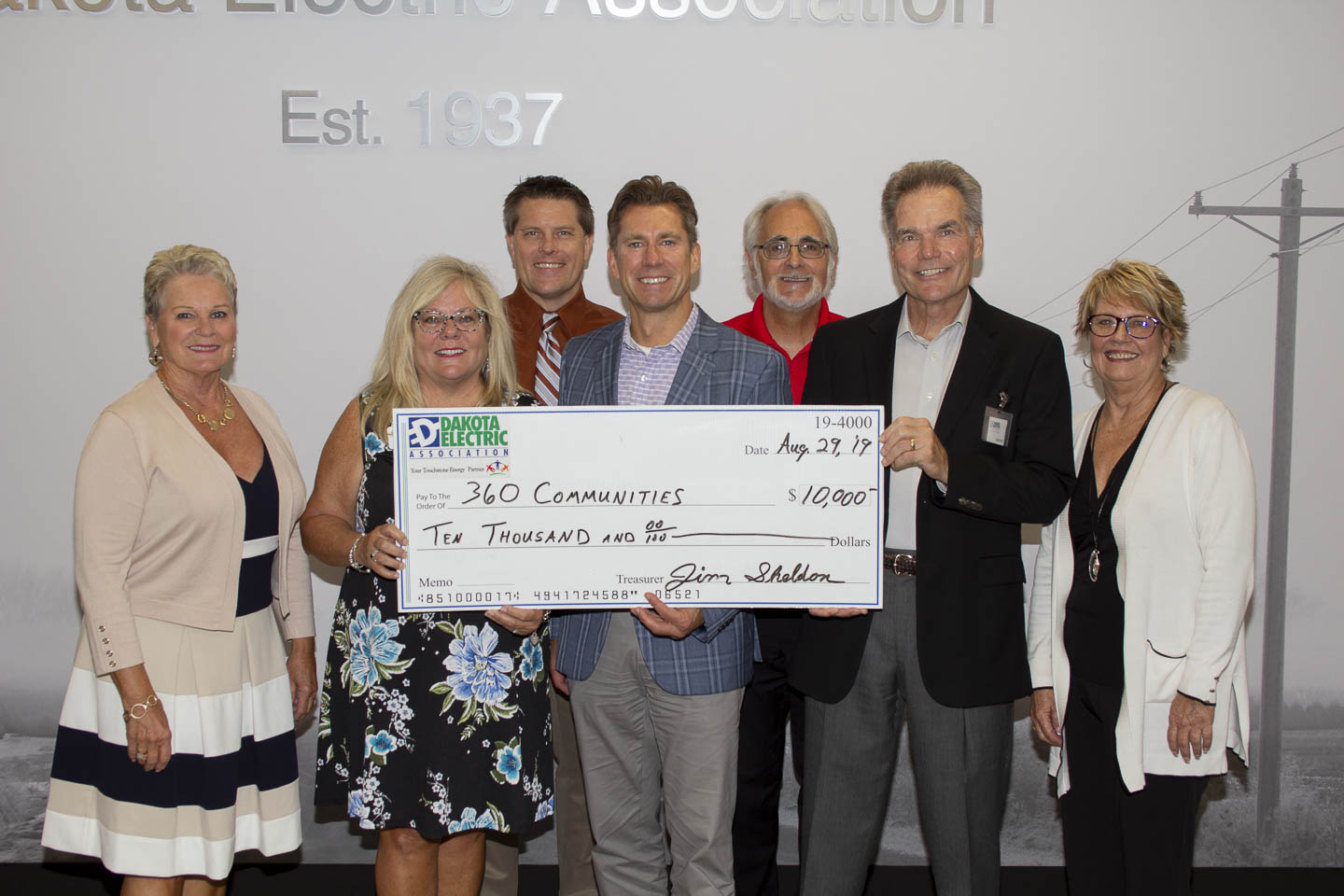 group of people holding large check