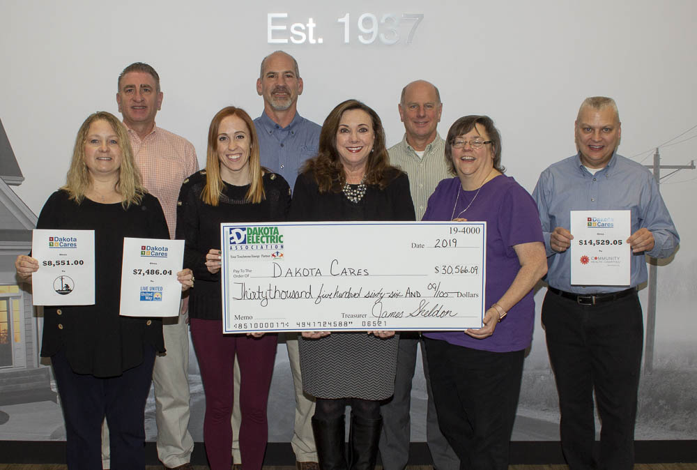 8 employees holding large check