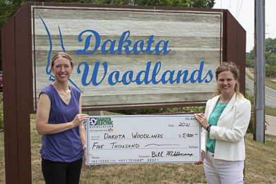 two people holding large check