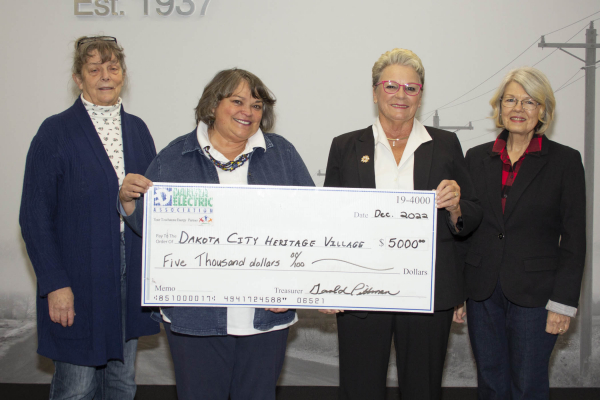 four women holding a large check