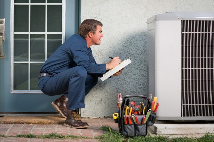 a man inspecting an outdoor air condition unit
