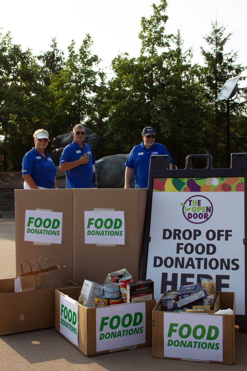 Dakota Electric staff and board members standing in front of big boxes filled with donated food.