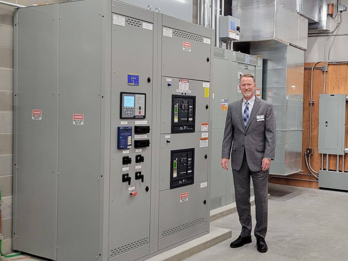 man in a suit in front of major electrical equipment